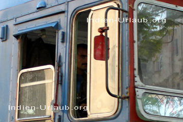 Busfahrer hinter dem Steuer von einem Ashok Leyland Doppeldecker-Bus in Mumbai dem ehemaligen Bombay für Touristen. Man beachte den Blinker an der Seite von dem Bus der noch mechanisch funktioniert.