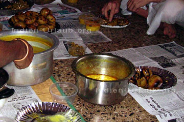 Ayurvedische Speisen bei den Indien Reisen. Das ist nicht außergewöhnlich das die Inder in ihren Wohnungen auf dem Boden essen der wie hier nochmals mit Zeitungen ausgelegt wurde. Man beachte die Anordnung der Schalen mit den einzelnen Speisen.