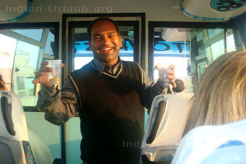 Unser indischer Reiseleiter im Bus immer zu einem Spass aufgelegt mit zwei Becher in der Hand wo er erklärt um was es sich dabei handelt. Wie man auf dem Bild vom Innern im indischen Touristenbus erkennt ist die Fahrgast-Kabine von dem indischen Busfahrer getrennt.