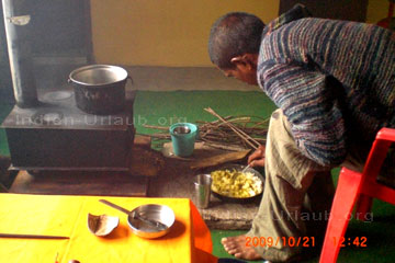 So eine Kochstelle wie man die hier auf dem Bild sieht, die ist schnell hergestellt beim Trekking in Indien. Hier sieht man gerade auf dem Bild wie ein Inder etwas zu essen in der Pfanne zubereitet hat, der Raum ist vom Rauch des Ofens erfüllt, deshalb ist dieses Bild von den Indien Reisen Jahr 2009 so trübe.