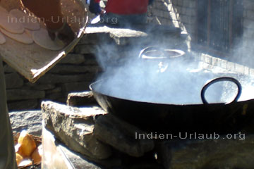 Inder bei der Zubereitung der Ayurvedischen Speisen wie hier wo die ausgerollten Teigfladen in Ghee ausgebacken werden, auf dem nächsten Bild der Ayurveda Rezepte erkennt man dann wie das frisch gebackene indische Brot lecker aussieht.