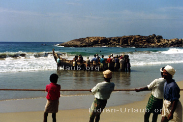Alltags-Szene der Fischer am Strand im indischen Bundesstaat Kerala, Südindien.