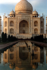 Das Taj Mahal in der Morgensonne betrachtet und wie sich das Grabmal in dem See spiegelt.